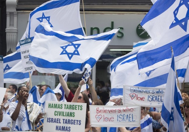 Demonstrators hold signs and Israeli flags during a rally outside Israel's Embassy in London, to show support for Israel's military action in Gaza