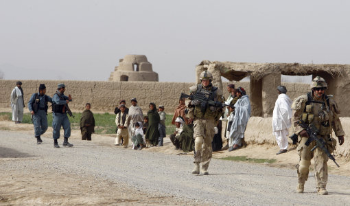In this Jan. 26, 2010 photo Canadian soldiers from Task Force 3-09 Battle Group walk with Afghan National Police Officers during operation Tazi, a village search and security operation in the Dand area of Kandahar Province, southern Afghanistan. (AP Photo/Kirsty Wigglesworth)