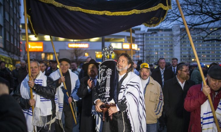 a-member-of-the-jewish-community-carries-torah-scrolls-during-the-dedication-service-of-the-new-synagogue-in-the-former-church-in-cottbus